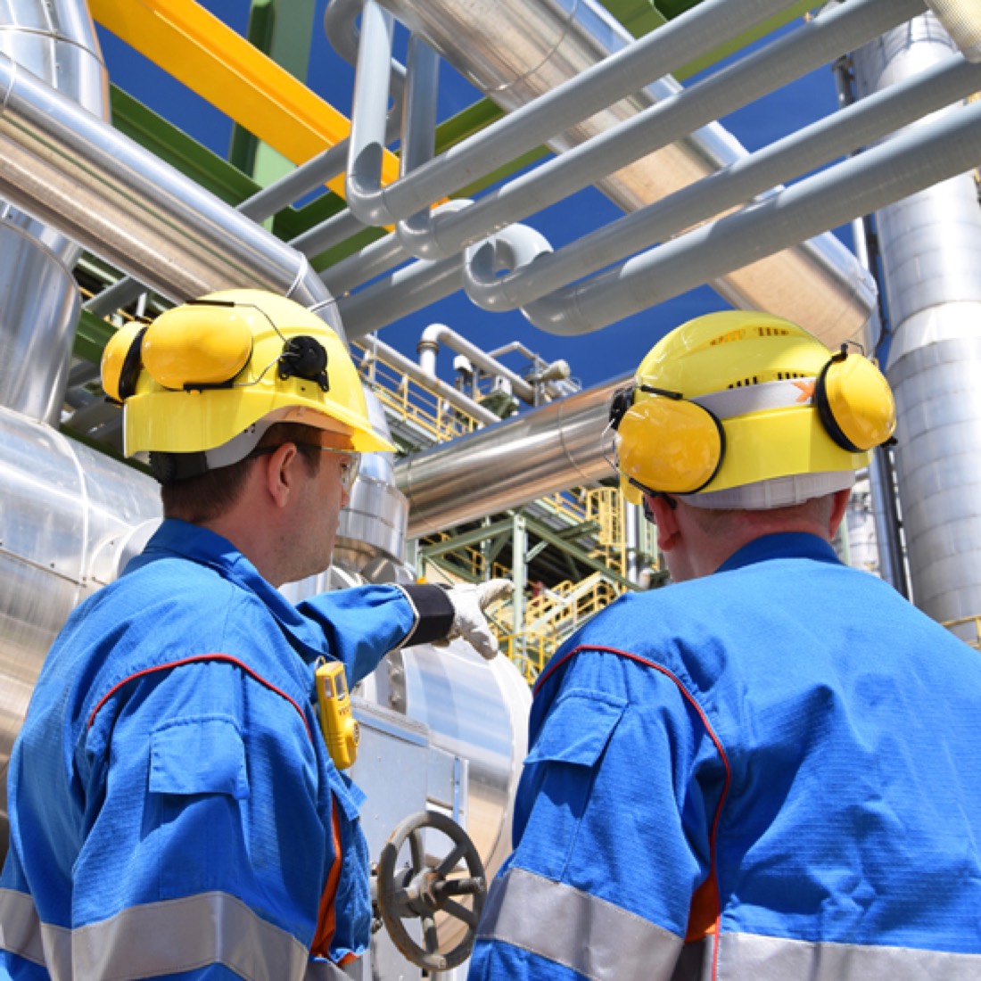 Operators in hard hats reviewing a document together