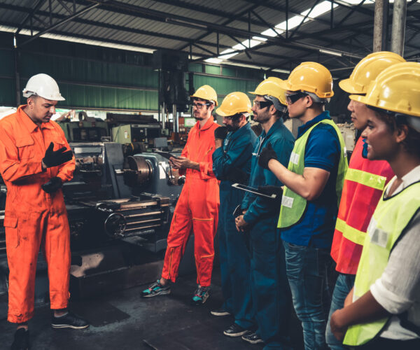 Skillful worker attending brief meeting in the factory . Industrial people and manufacturing labor concept .