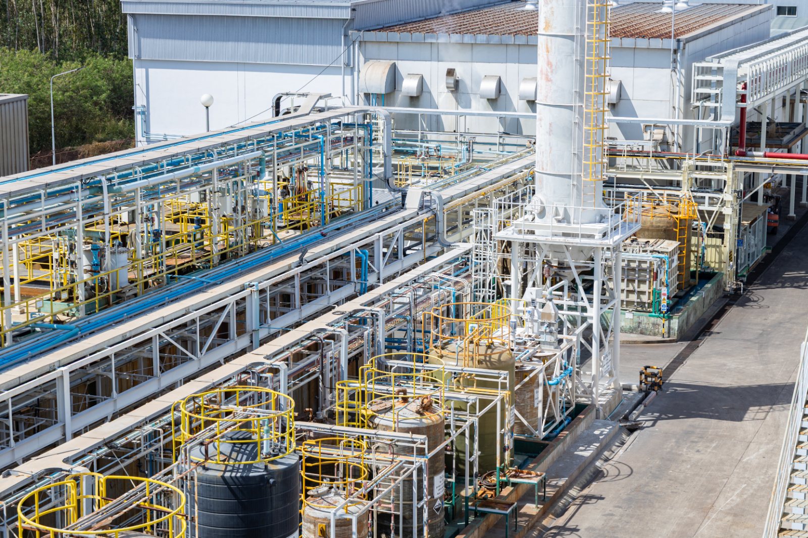 Chemical plant with storage tanks, pipe racks and yellow safety cages