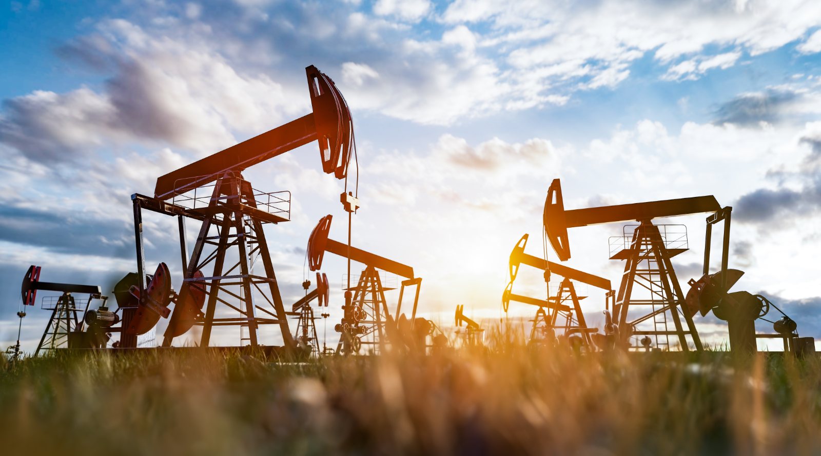 Row of pumpjacks at sunset