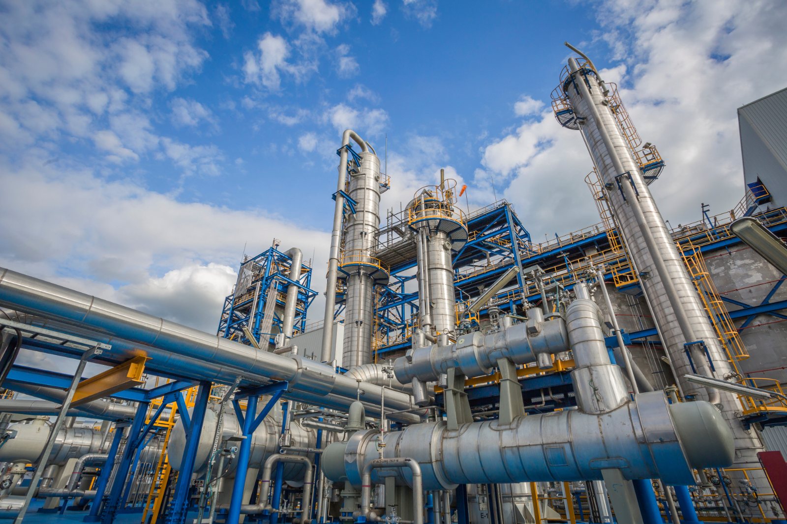 Process plant towers and piping against a blue sky